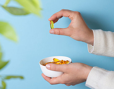 Hand mit Vitamin-D-Pillenschale