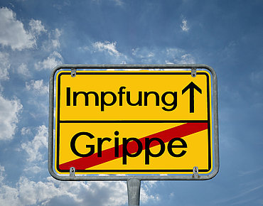 Ortsschild mit Impfung voraus und Grippe zurück