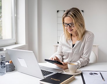 Frau arbeitet im Büro am Laptop