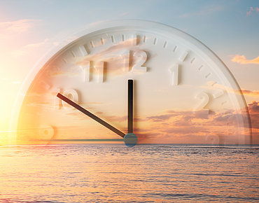 Uhr, die halb im Meer versunken ist