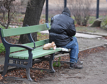 Obdachlose Person auf einer Parkbank