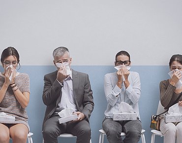 Vier kranke Personen im Wartezimmer für eine AU