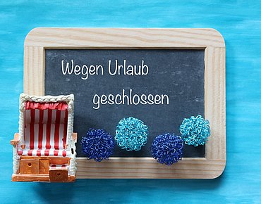 Tafel mit Aufschrift: Wegen Urlaub geschlossen