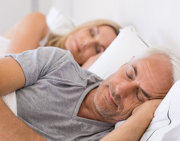 Ehepaar schläft in einem Bett