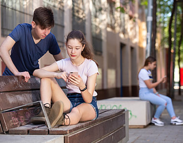 Jugendliche blicken zusammen in ein Smartphone