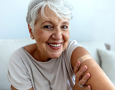 Ältere Dame mit Pflaster am Oberarm