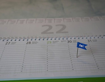 Kalender mit einem Fähnchen am Freitag, auf dem "frei" steht.