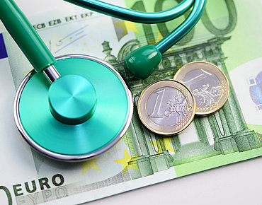 Grünes Stethoskop auf einem hunderd Euro Schein