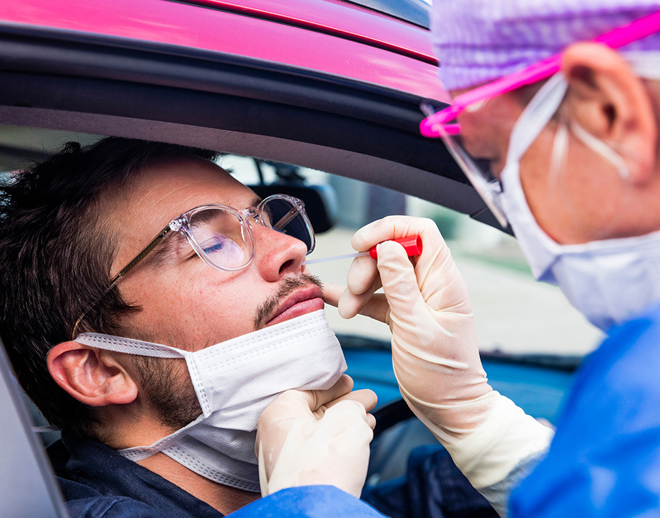 Mann macht einen Corona Test im Auto