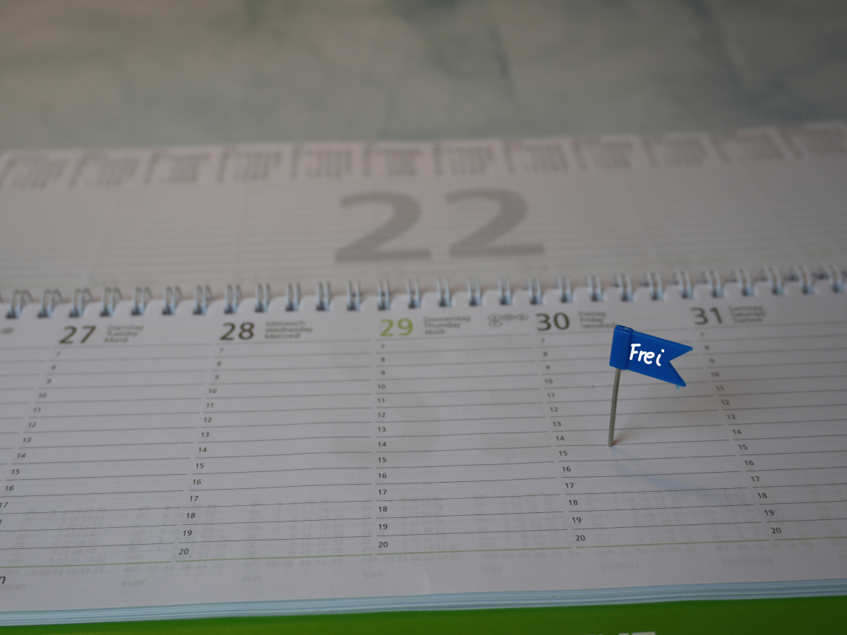 Kalender mit einem Fähnchen am Freitag, auf dem "frei" steht.