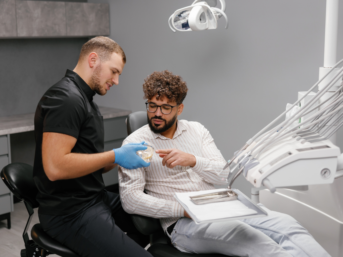 Zahnarzt erklärt Patient Aufbissbehelfe