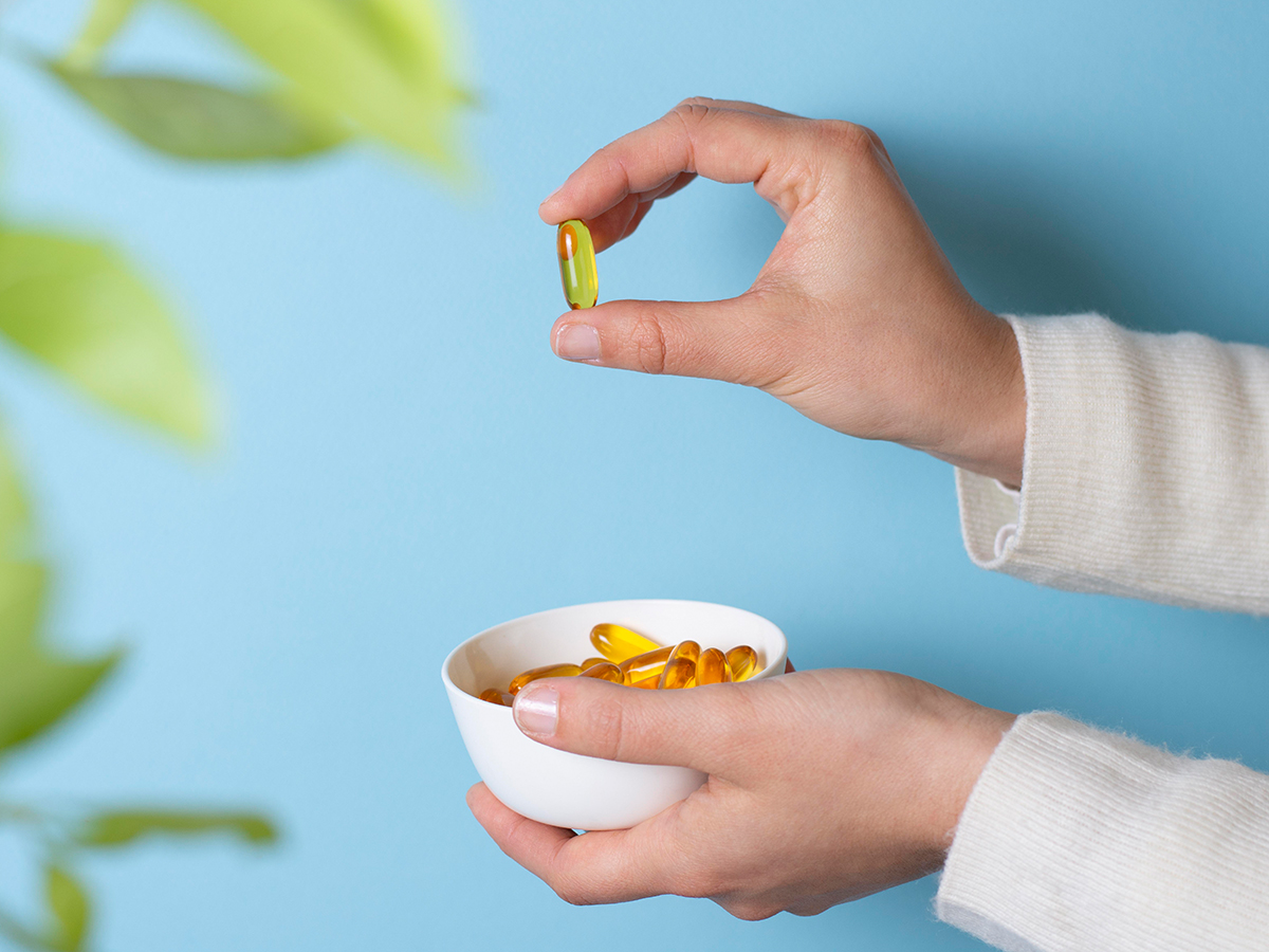 Hand mit Vitamin-D-Pillenschale
