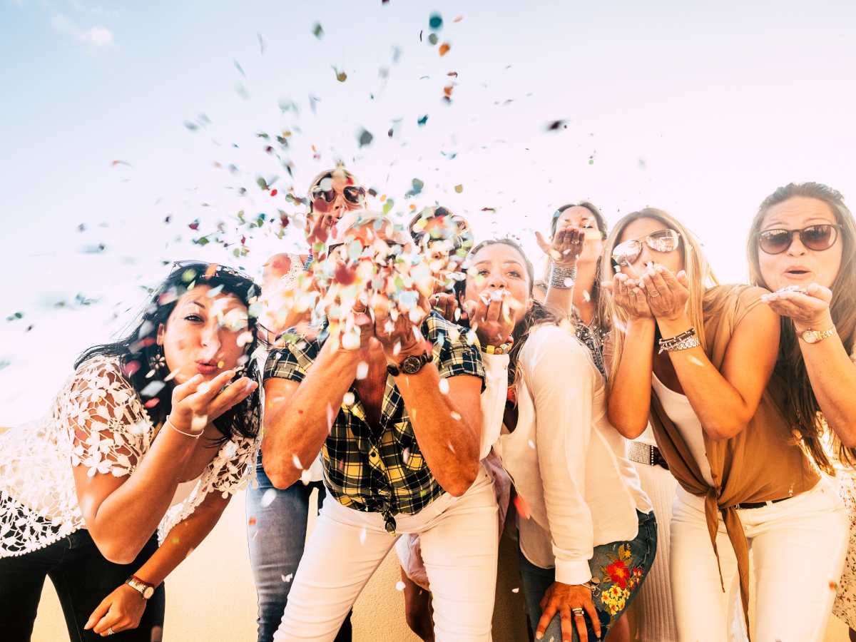 Grupper pustet Konfetti in die Kamera