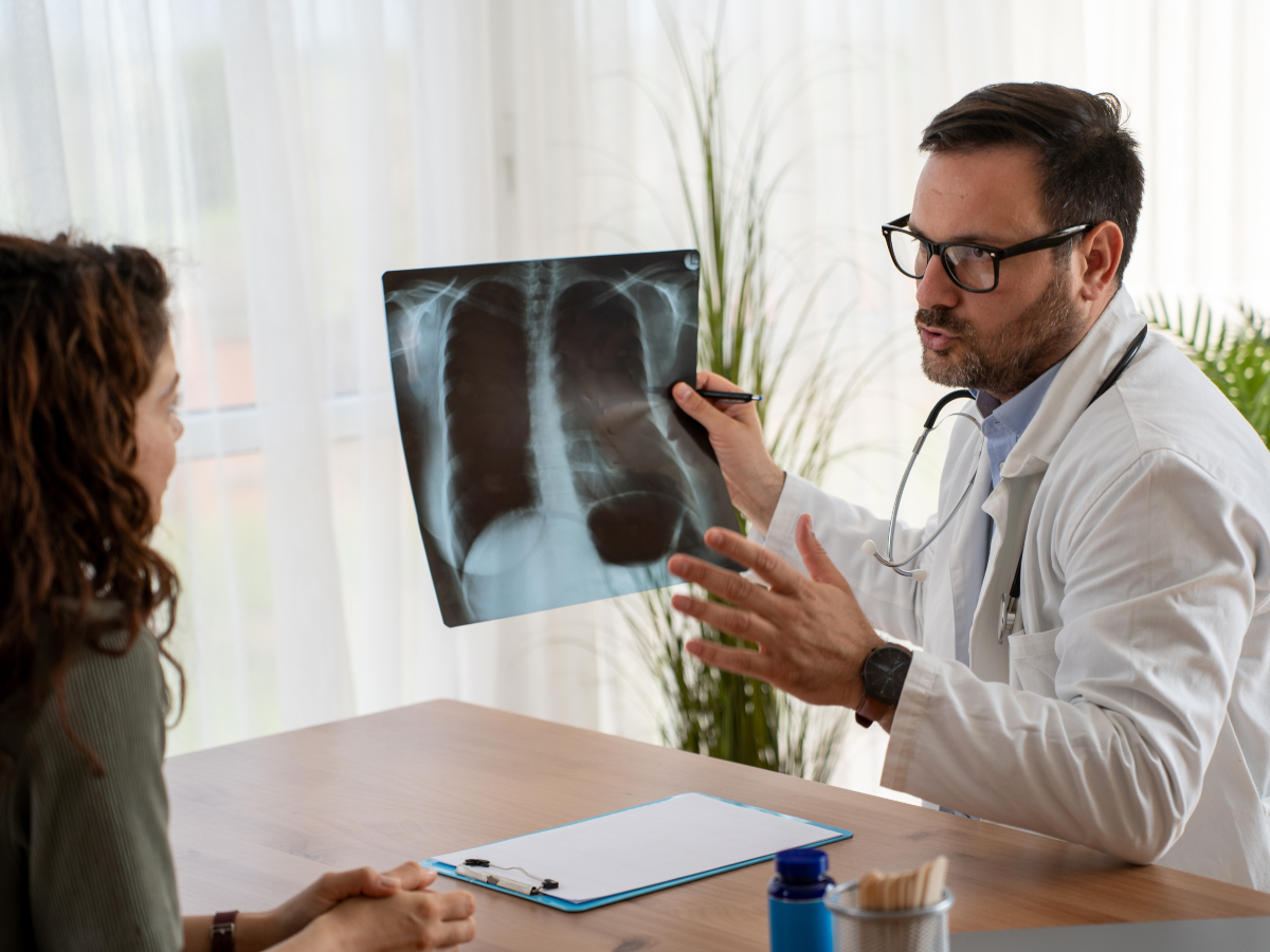 Arzt zeigt Patientin Röntgen
