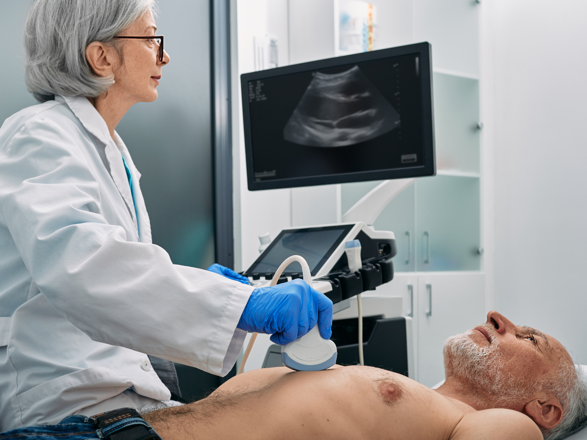 Ärztin führt Sonographie am Oberkörper eines Mannes durch
