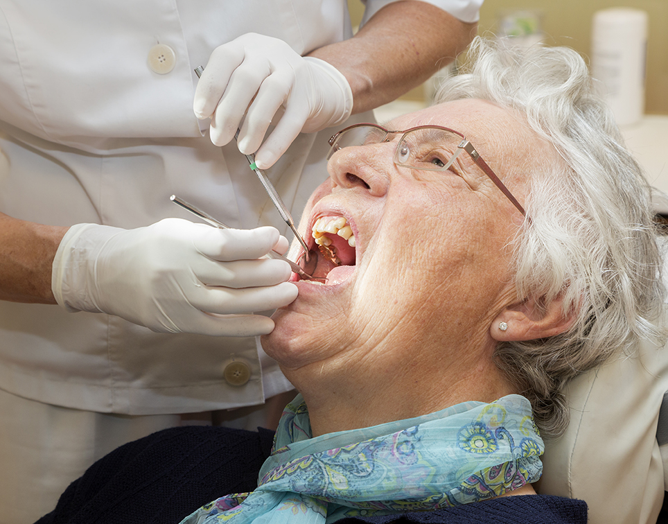 Ältere Dame wird vom Zahnarzt untersucht