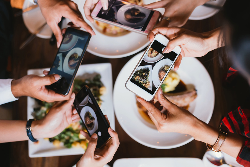 Restaurant Besucher schießen Fotos von ihren bestellten Gerichten