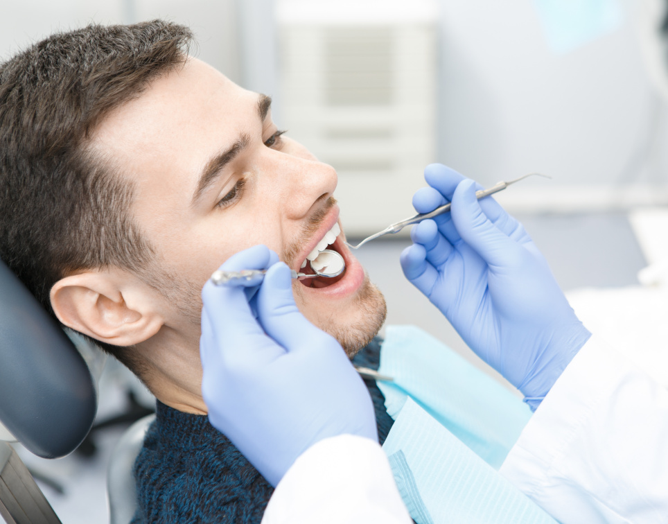 Mann wird beim Zahnarzt behandelt